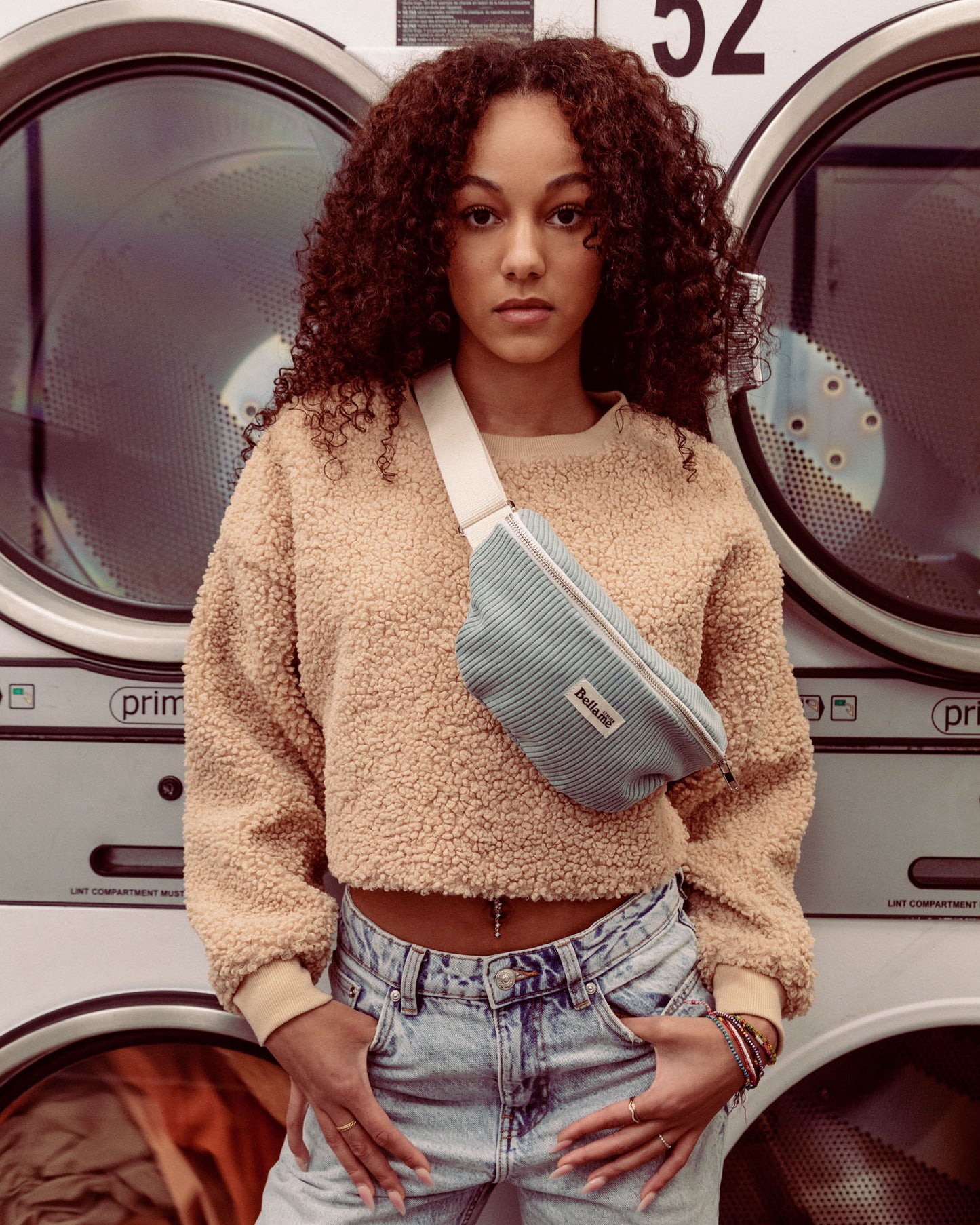 Sac Banane couleur gris/bleu (La célèste) portée par une femme dans une laverie