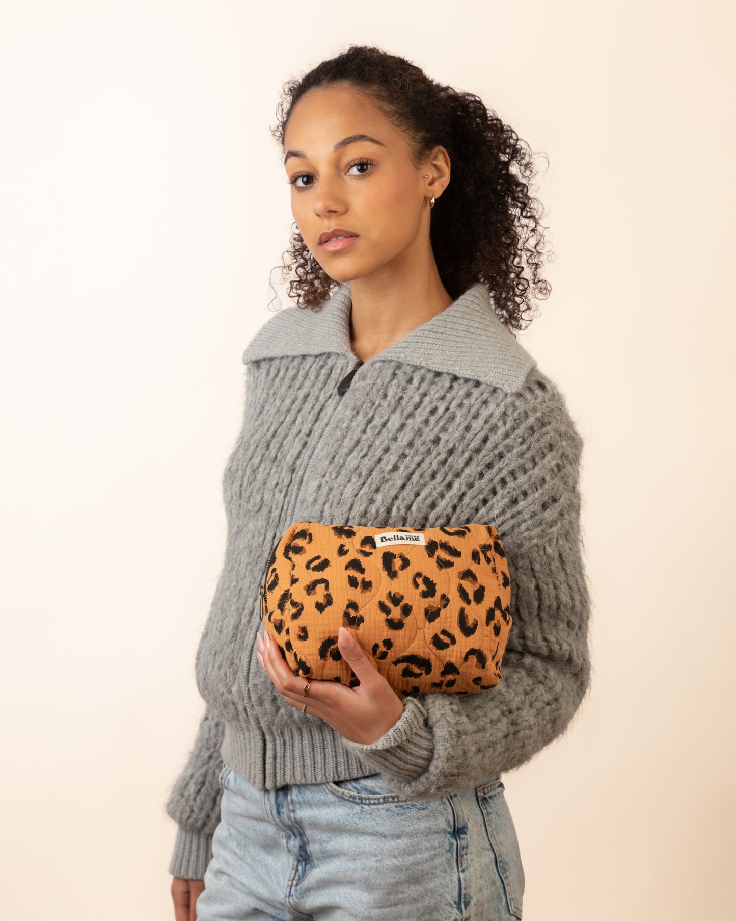 Trousse La Féline tenue par une femme sur fond blanc