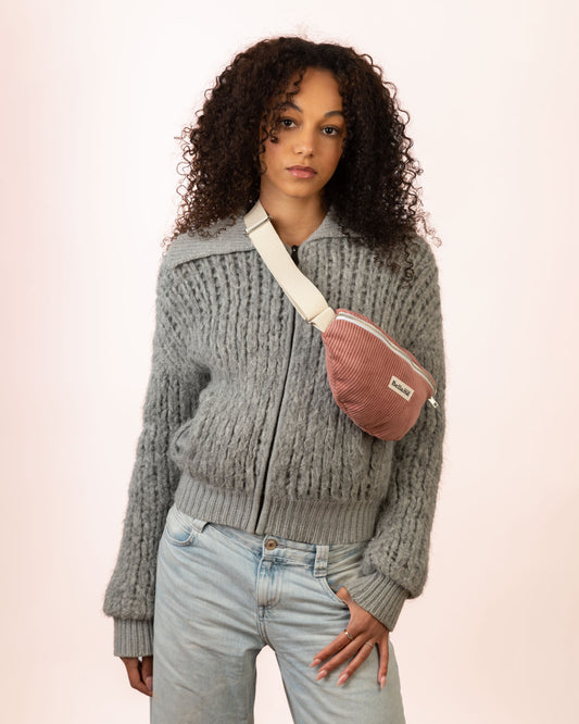 Sac Banane couleur rose clair (La Rosée) portée par une femme sur fond blanc
